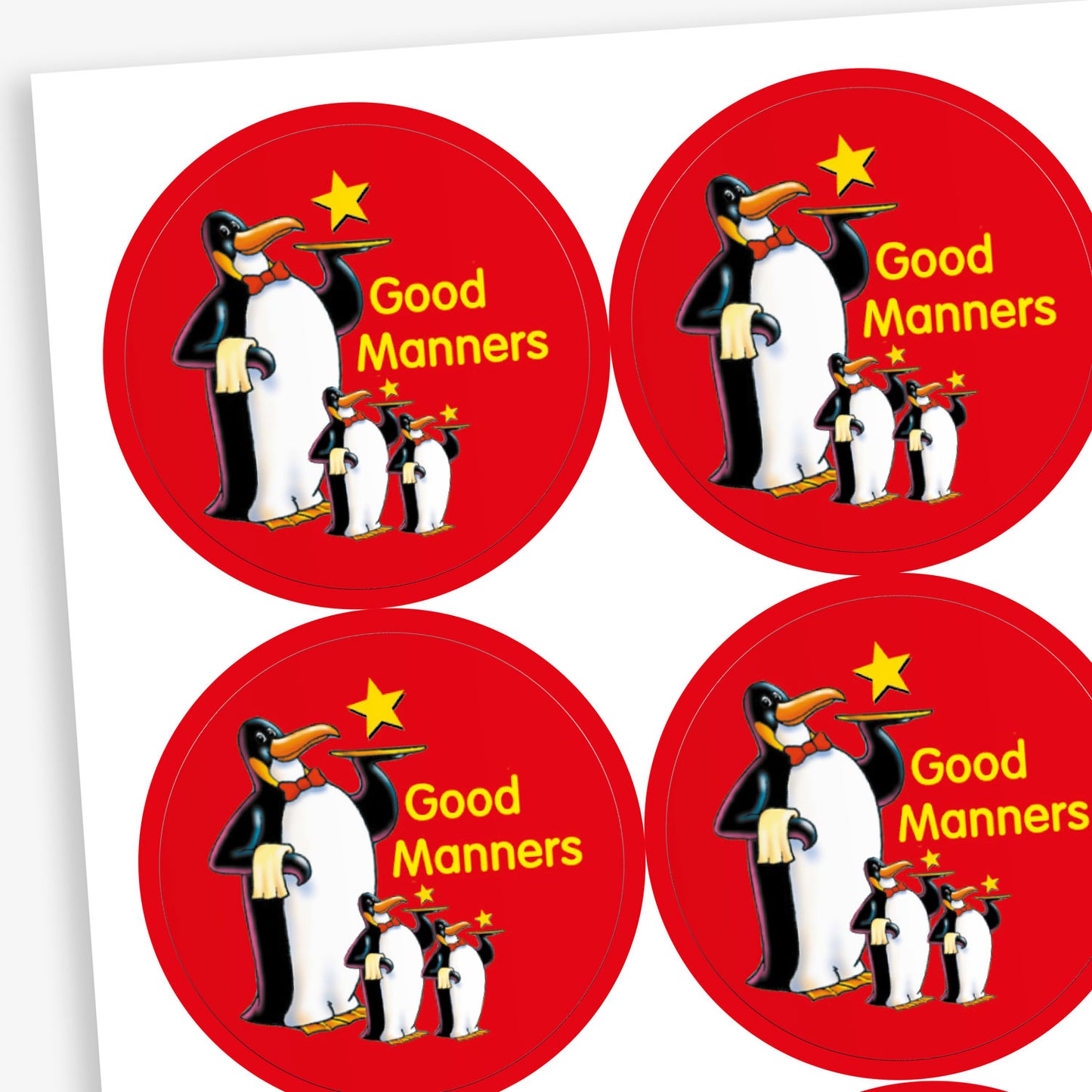 A sheet of red circular reward stickers for children. Each sticker features a group of three cartoon penguins standing together, with a yellow star above them and the phrase 'Good Manners' written in yellow text.