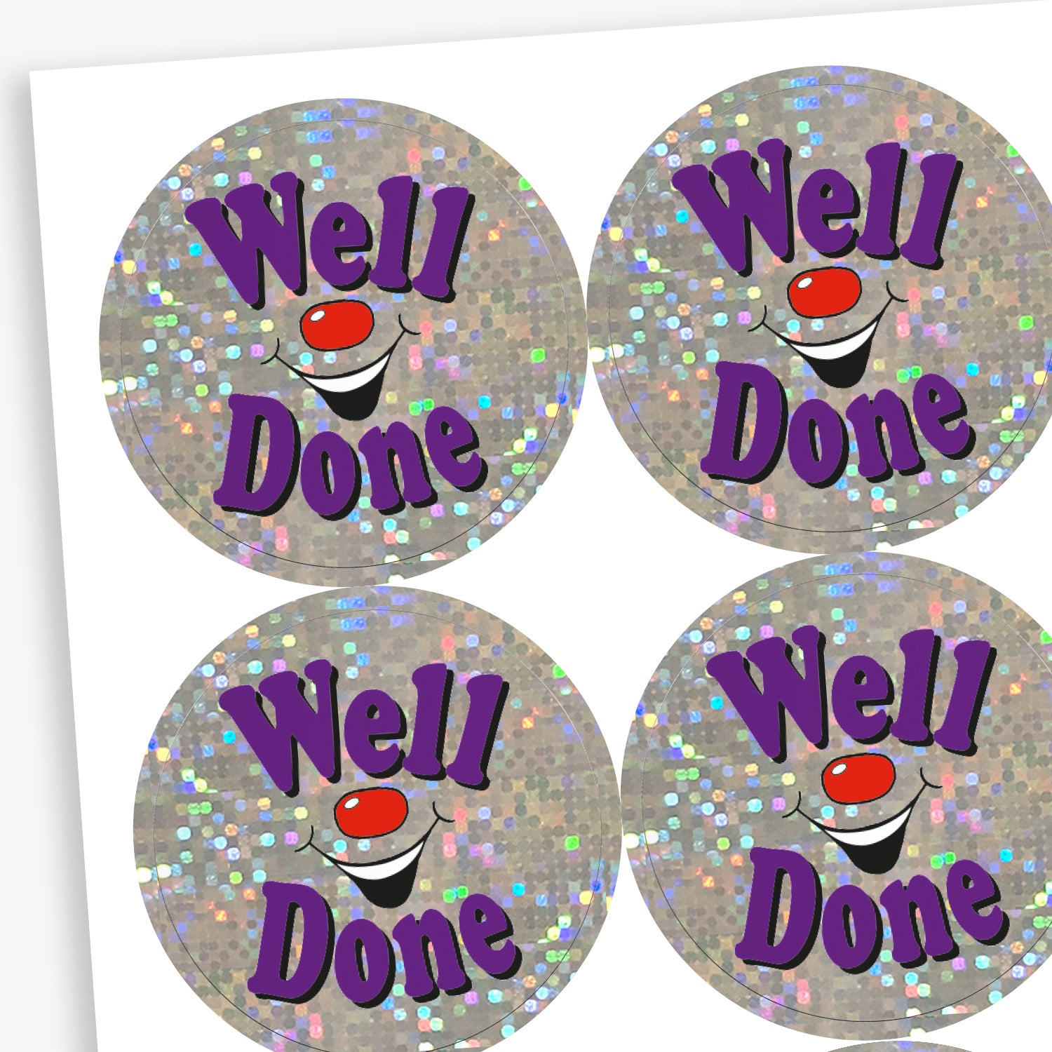 A sheet of holographic circular stickers featuring the text "Well Done" in purple, surrounded by sparkling silver glitter and a smiling clown face.