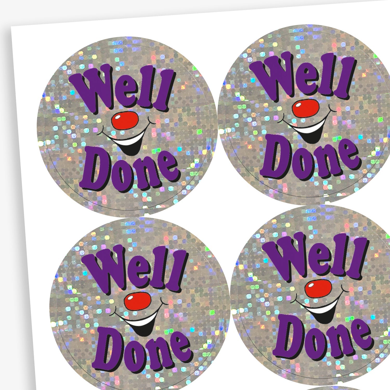 A sheet of holographic circular stickers featuring the text "Well Done" in purple, surrounded by sparkling silver glitter and a smiling clown face.