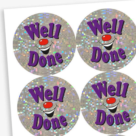 A sheet of holographic circular stickers featuring the text "Well Done" in purple, surrounded by sparkling silver glitter and a smiling clown face.