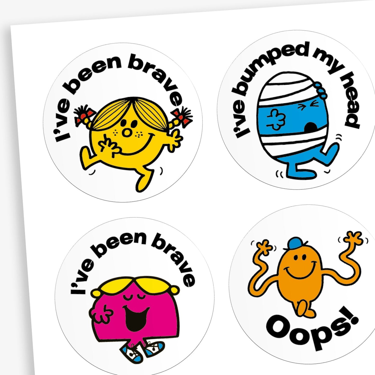 A snapshot of a sheet of circular reward stickers featuring Mr. Men and Little Miss characters on a white background.  Each sticker includes phrases relevant to first aid situations such as 'I've bee brave', 'I've bumped my Head' and 'Oops!' along with different Little Miss or Mr Men characters.