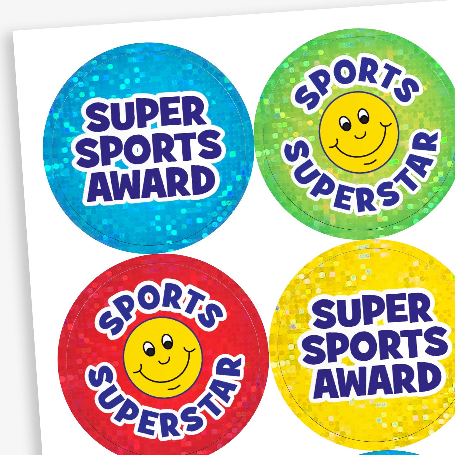 A snapshot showing four circular reward stickers for children with holographic backgrounds. Two stickers say 'SUPER SPORTS AWARD' in bold purple text—one with a blue background, the other yellow. The other two stickers read 'SPORTS SUPERSTAR' and feature a smiling yellow face—one with a green background, the other red.