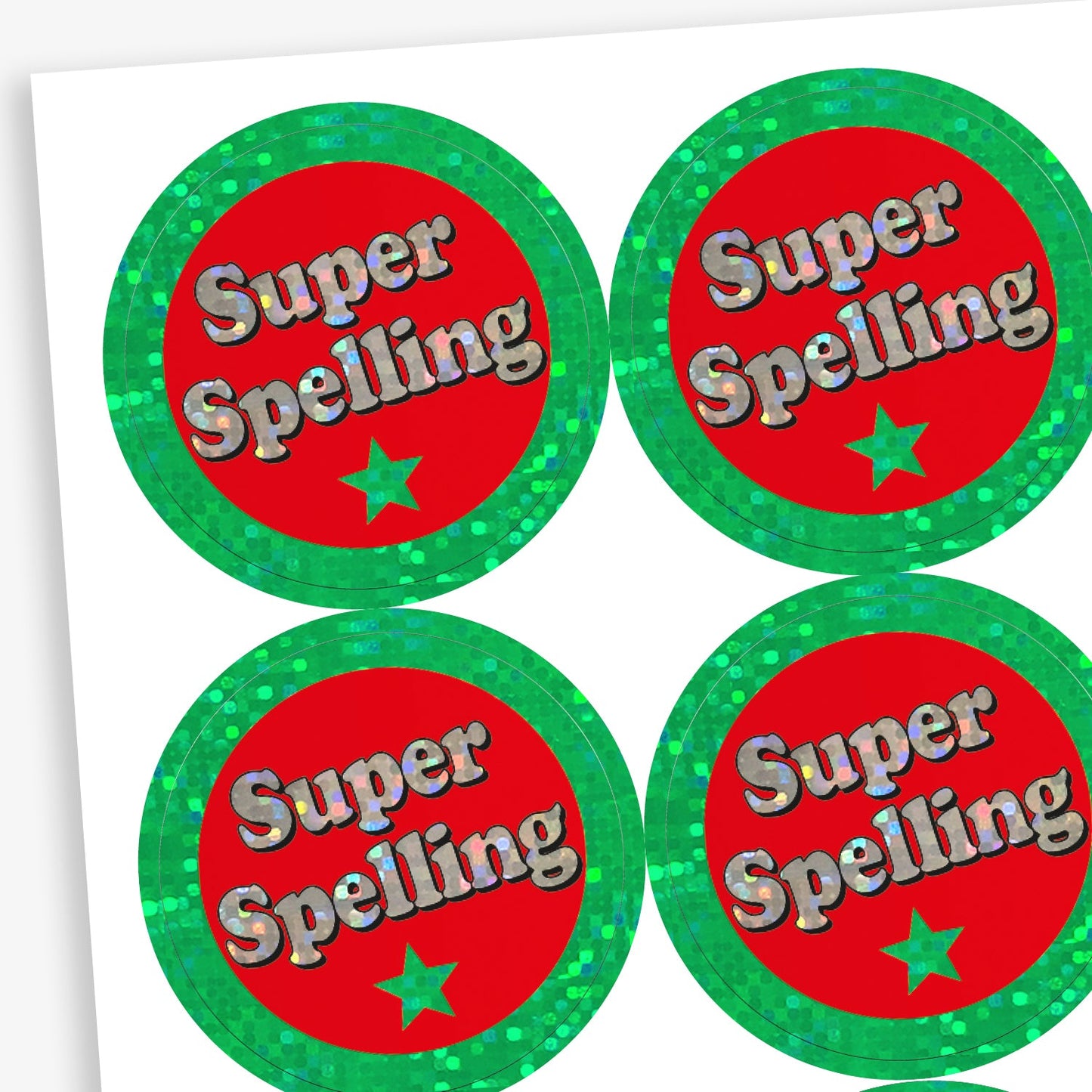 A sheet of holographic circular reward stickers. Each sticker has a red centre, a shiny green border, and the phrase 'Super Spelling' in silver text with a green star underneath.
