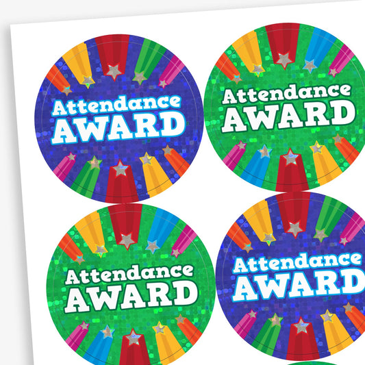 A sheet of circular 'Attendance Award' stickers with vibrant, holographic-style backgrounds in blue, green, and multicolour. Each sticker features bold white text and rainbow-coloured rays with stars shooting upwards.
