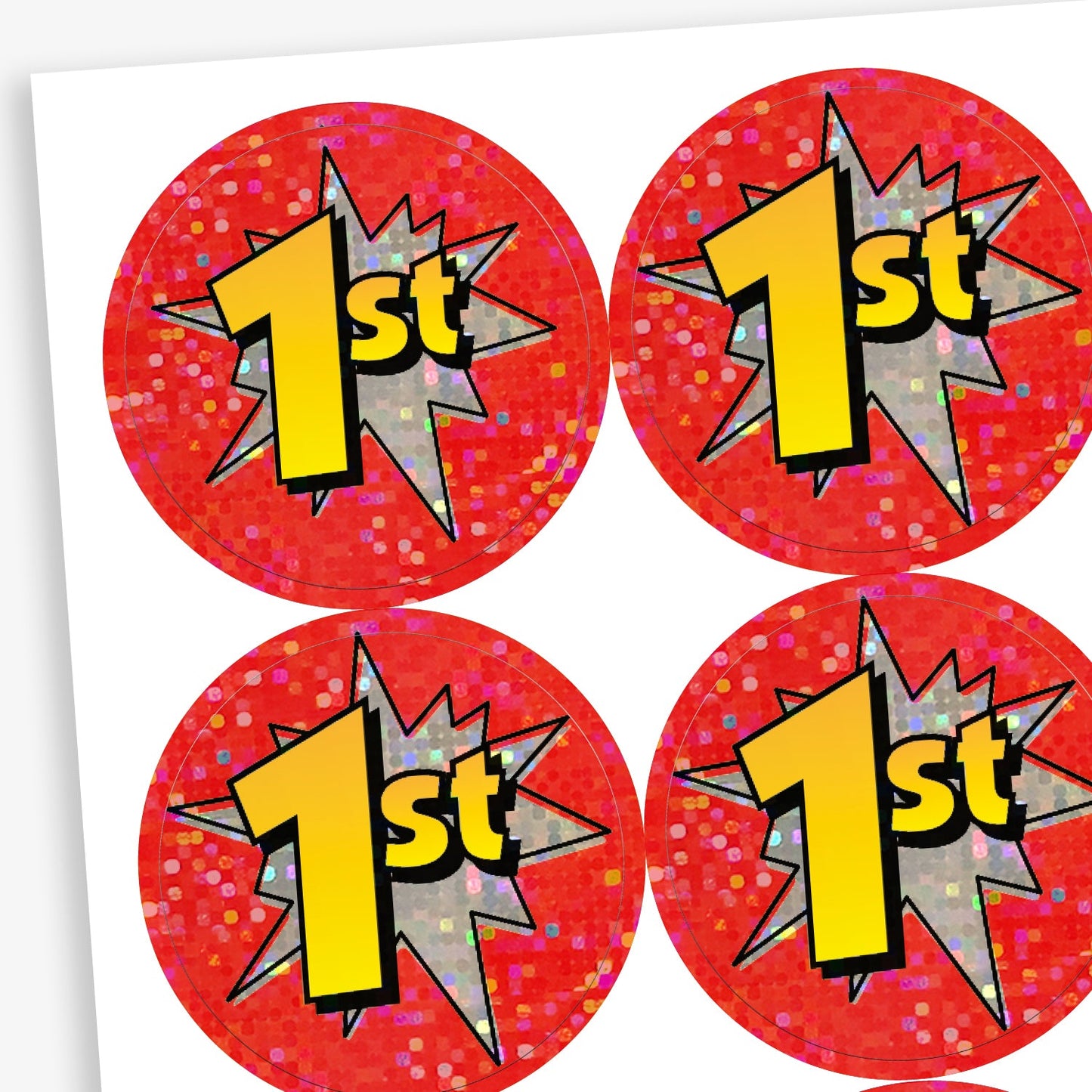 A sheet of holographic circular reward stickers with a red glittery background. Each sticker features a large yellow and black '1st' in a comic-style font, placed over a grey starburst graphic, indicating first place.