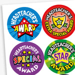 A sheet of colourful circular stickers celebrating pupil achievement with messages from the headteacher. Designs include: 'Headteacher’s Award' with a red star on blue, 'Headteacher’s Extra Special Award' with a gold shield on red, 'Headteacher’s Special Award' in bold text on purple, and 'Headteacher’s Star Award' with a purple star on green. Each sticker is bright and eye-catching.