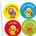 A sheet of vibrant round stickers, each with a monster as the main image and phrases such as 'I am a superstar!', 'I am a genius!', 'I am fab' and 'My brain is brilliant'.