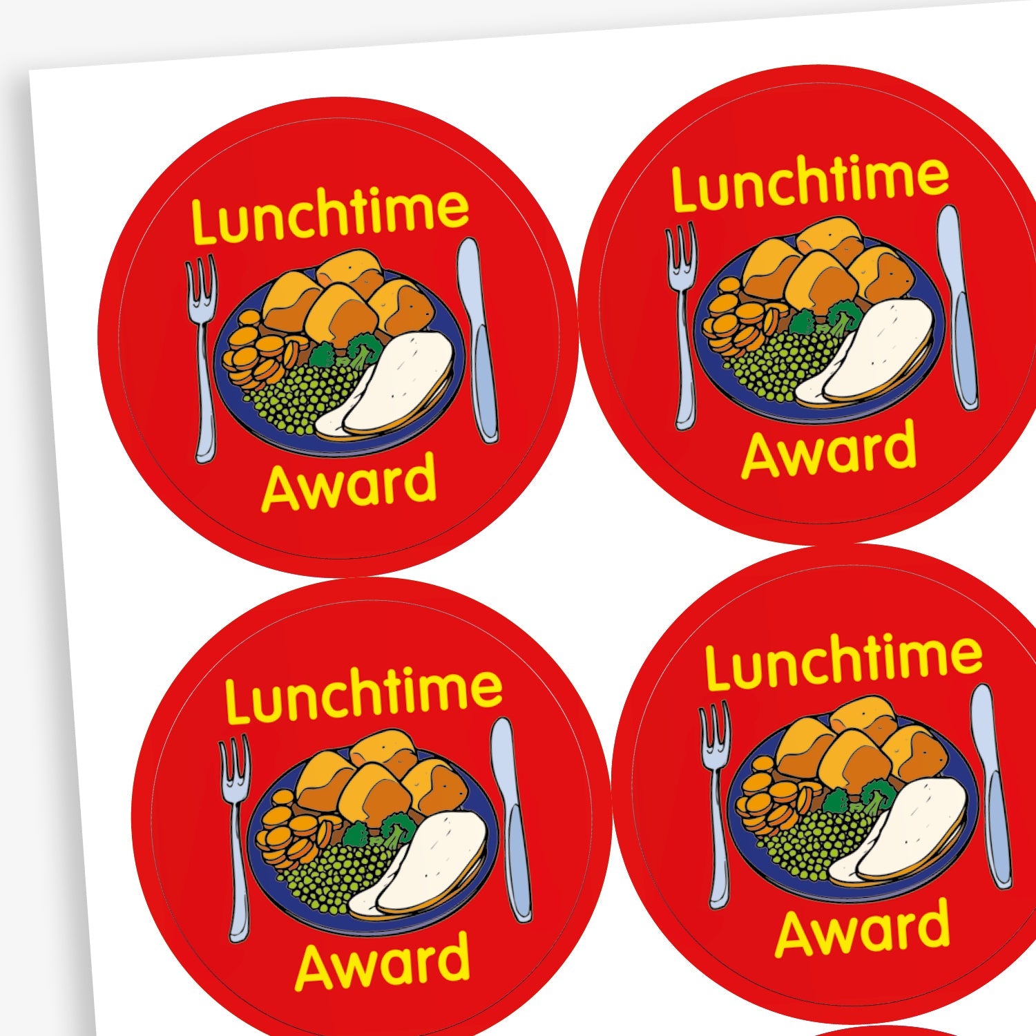 A sheet of circular reward stickers with a red background, each featuring a colourful illustration of a dinner plate with vegetables, potatoes, and a drink. The text 'Lunchtime Award' is written in yellow above and below the image. Each sticker also includes a knife and fork graphic on either side of the plate. 