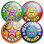 Four circular badges with the text 'Headteacher’s Award' encircling a large smiling cartoon star. Each badge has a vibrant background: green with a purple star, red with a yellow star, orange with a pink star, and navy blue with a blue star. Designed to recognise outstanding achievement or behaviour in school.
