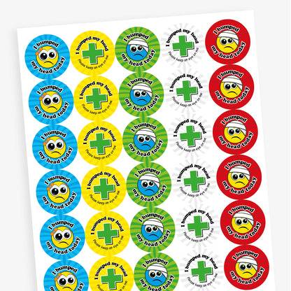 Sheet of vibrant coloured circular stickers with two main designs.  A cartoon face with a plaster or bandage on the head has text surrounding the image saying 'I bumped my head today!'; the seconf is a central first aid cross with the words 'I bumped my head today.  Please keep an eye on me' sorrounding it