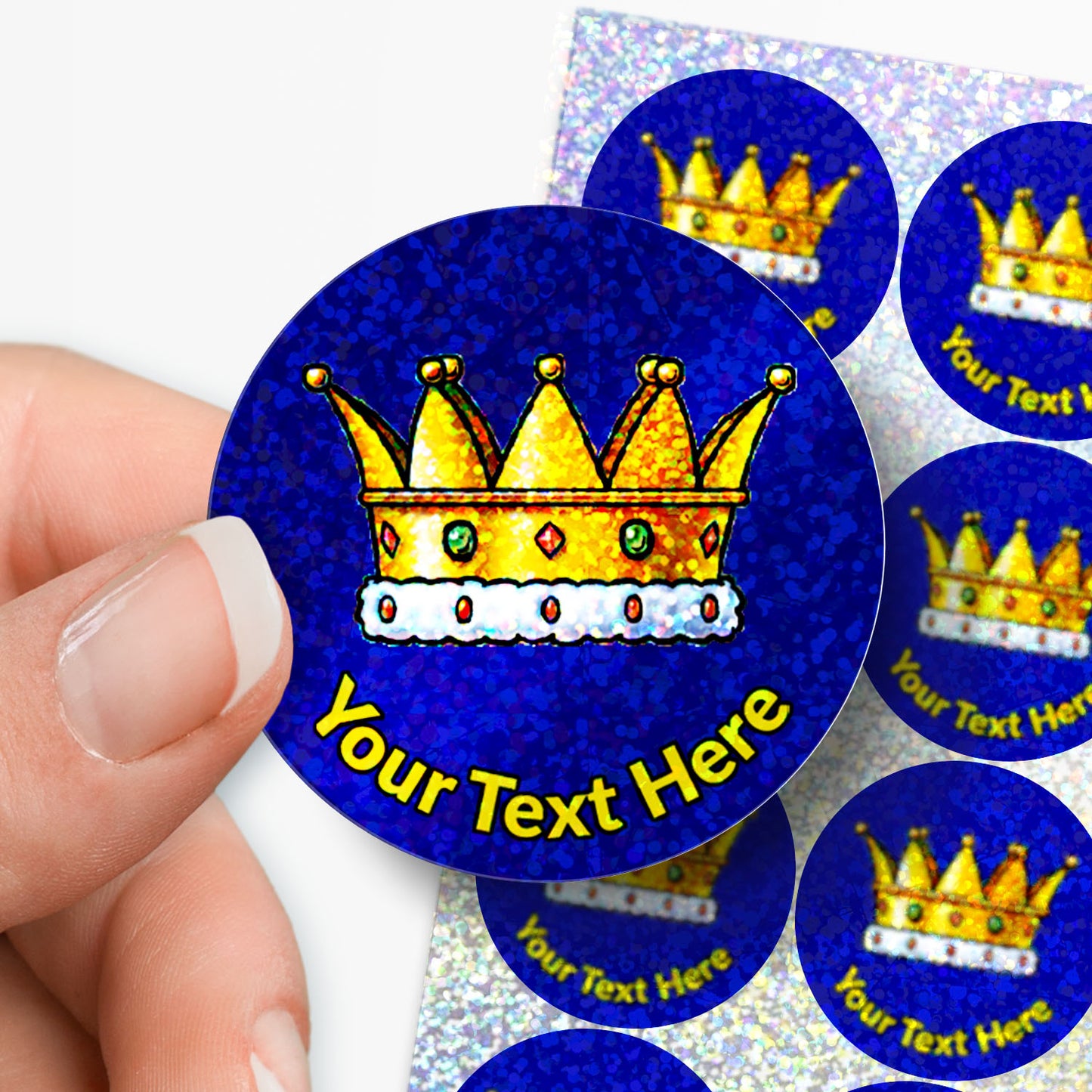 Sticker with a gold crown design and 'Your Text Here' text, held by a hand.