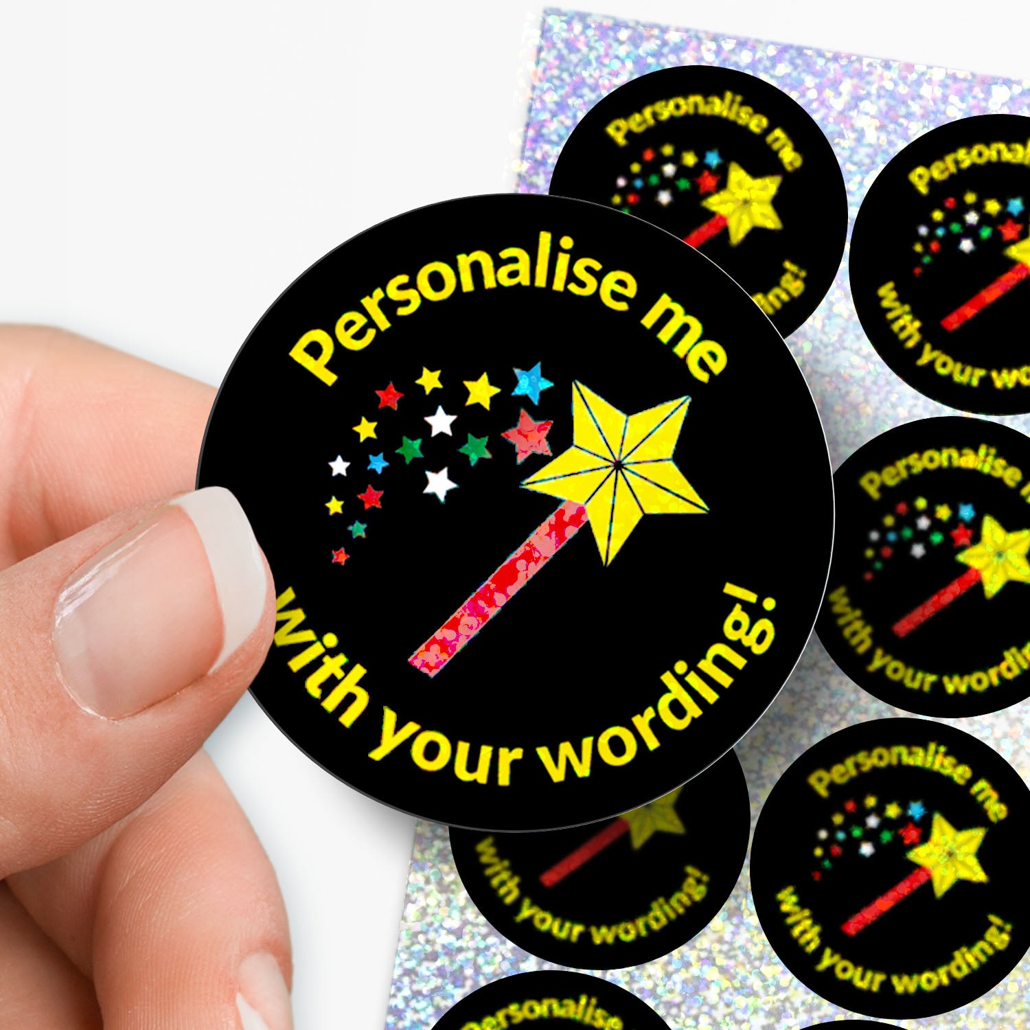 Black stickers with yellow text and star designs, held by a hand.