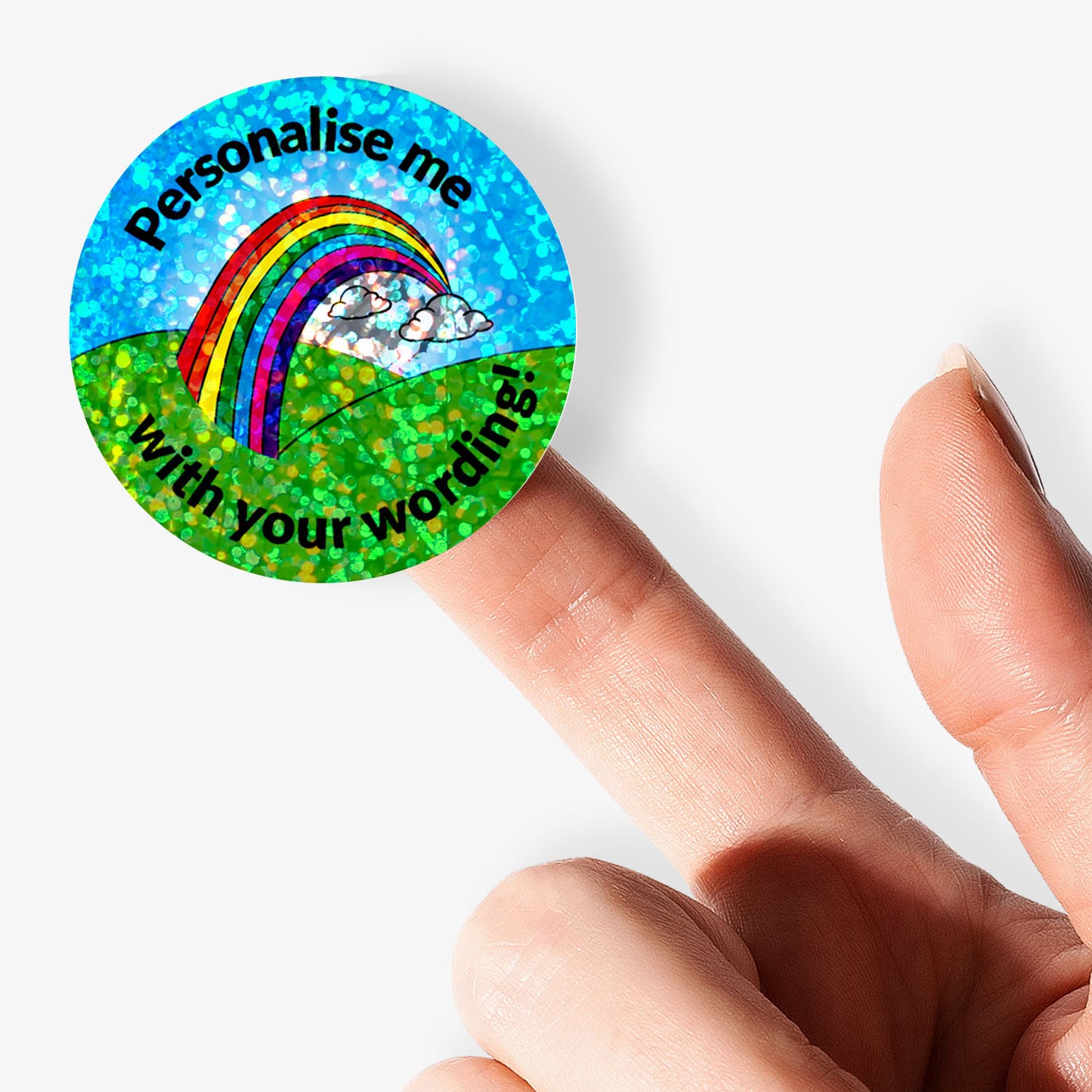 Round holographic sticker with rainbow and text 'Personalise me with your wording!' held by a finger.