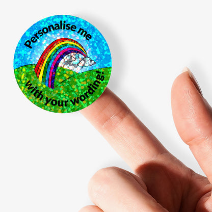 Round holographic sticker with rainbow and text 'Personalise me with your wording!' held by a finger.