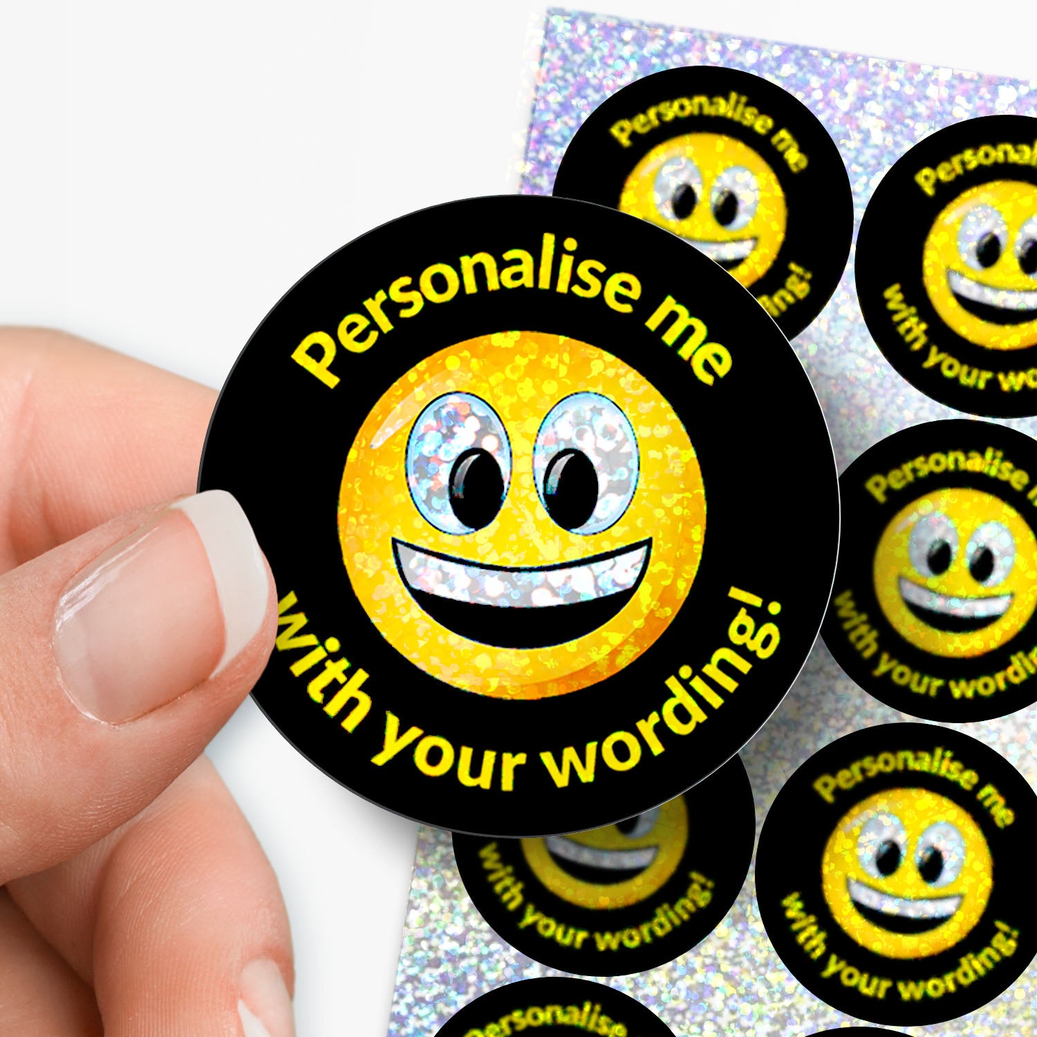 Smiley face stickers with 'Personalise me with your wording!' text, held by a hand.