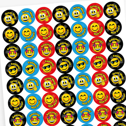 A sheet of colourful reward stickers featuring cheerful smiley faces with different expressions. Each circular sticker includes praise such as 'Great Work', 'Well Done!', 'Fantastic', and 'Amazing!'. The backgrounds are in bright colours like black, blue, and red, with each smiley wearing accessories like sunglasses or stars, designed to celebrate effort and achievement.