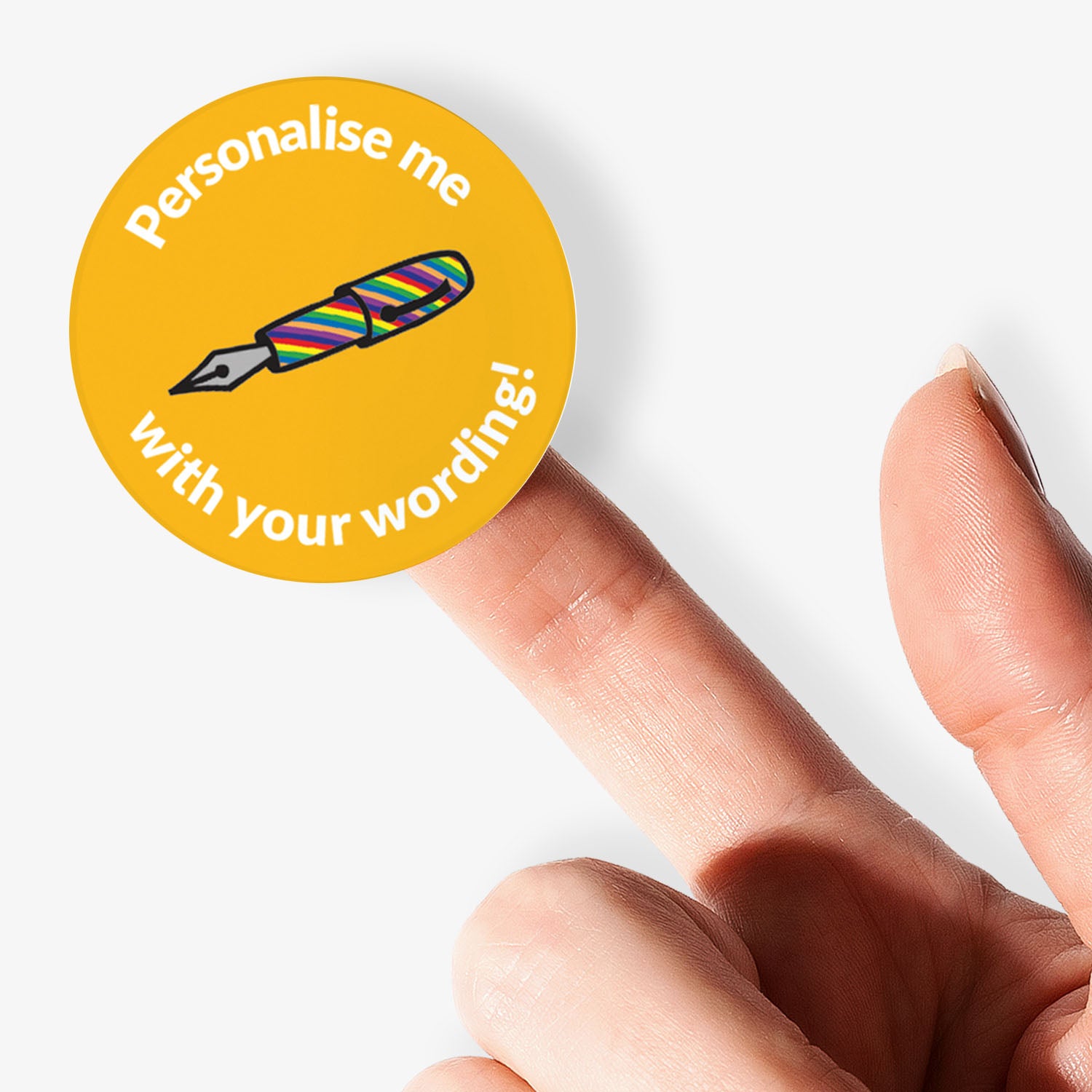 Round yellow sticker with text and a colorful pen illustration, held by a hand.