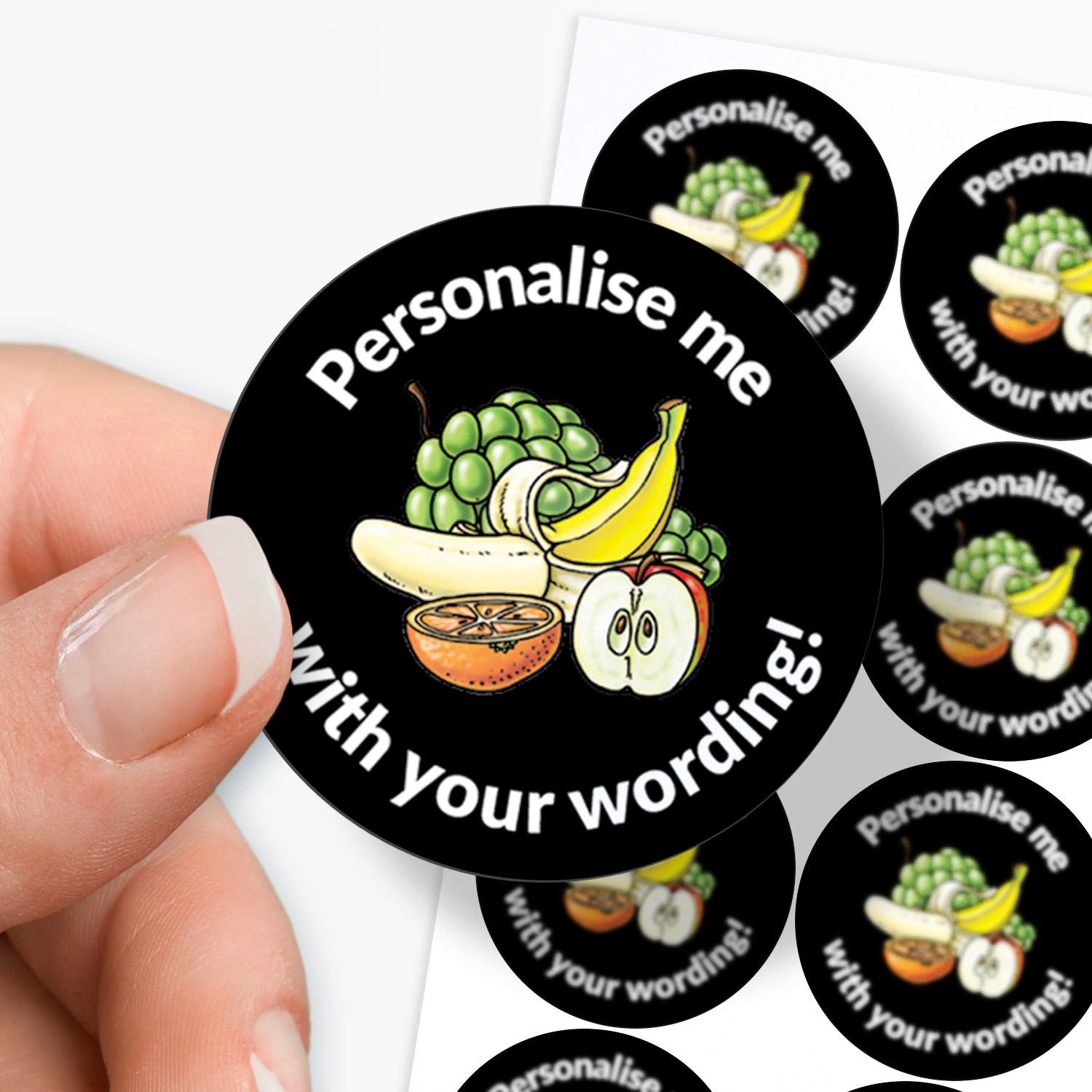 Round customizable sticker with fruit design and text 'Personalise me with your wording!' held by a hand.
