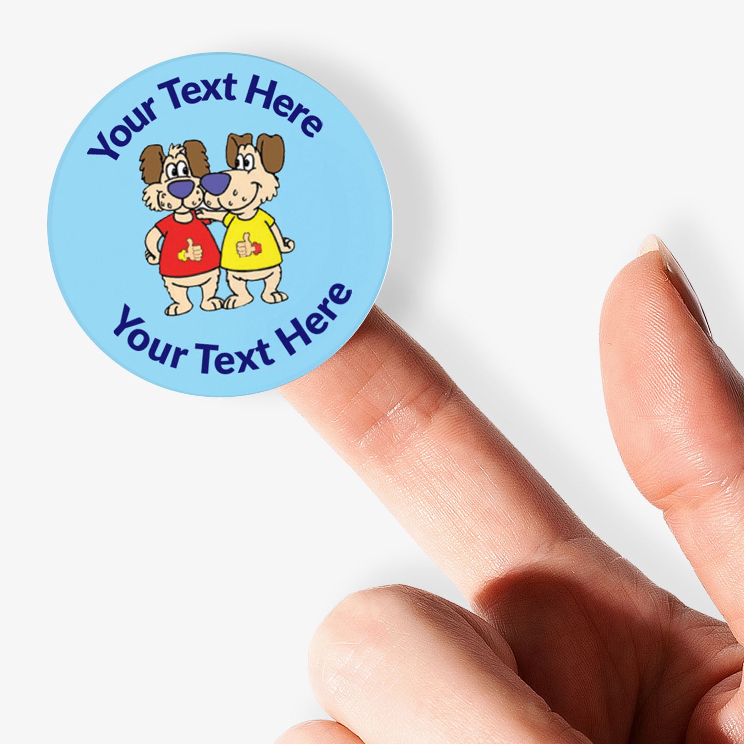 Round sticker with cartoon dog characters and text, held by a hand on a white background.