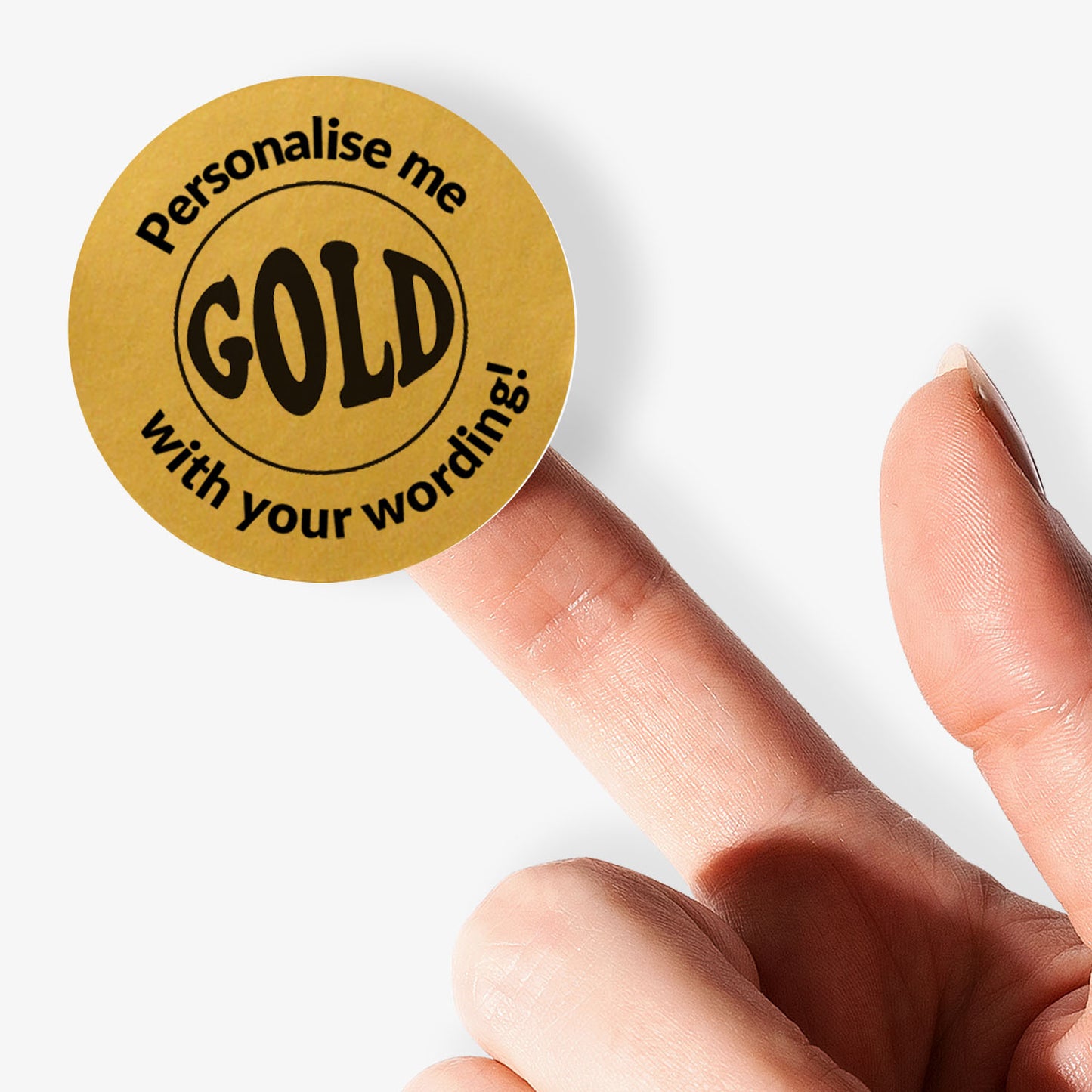 Gold circular sticker with 'Personalise me with your wording!' text held on finger.