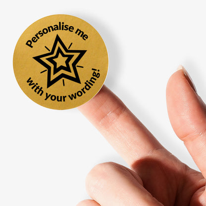 Personalised gold sticker with star design and text 'Personalise me with your wording!' held by a finger.