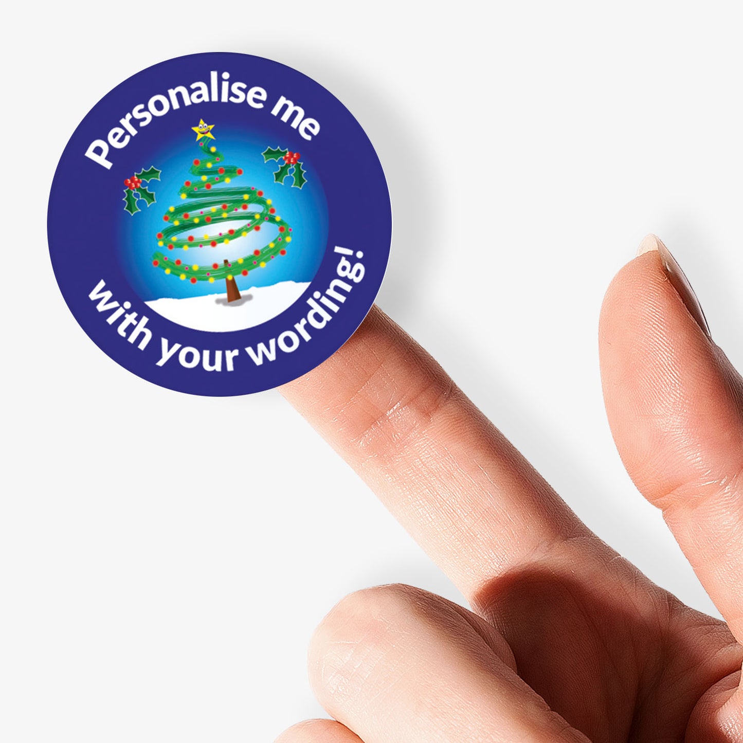 Round sticker with Christmas tree design and text 'Personalise me with your wording!' held between fingers.