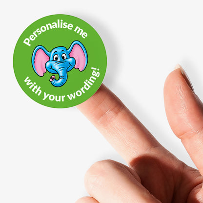 Green sticker with an elephant design and text 'Personalise me with your wording!' held by a finger.