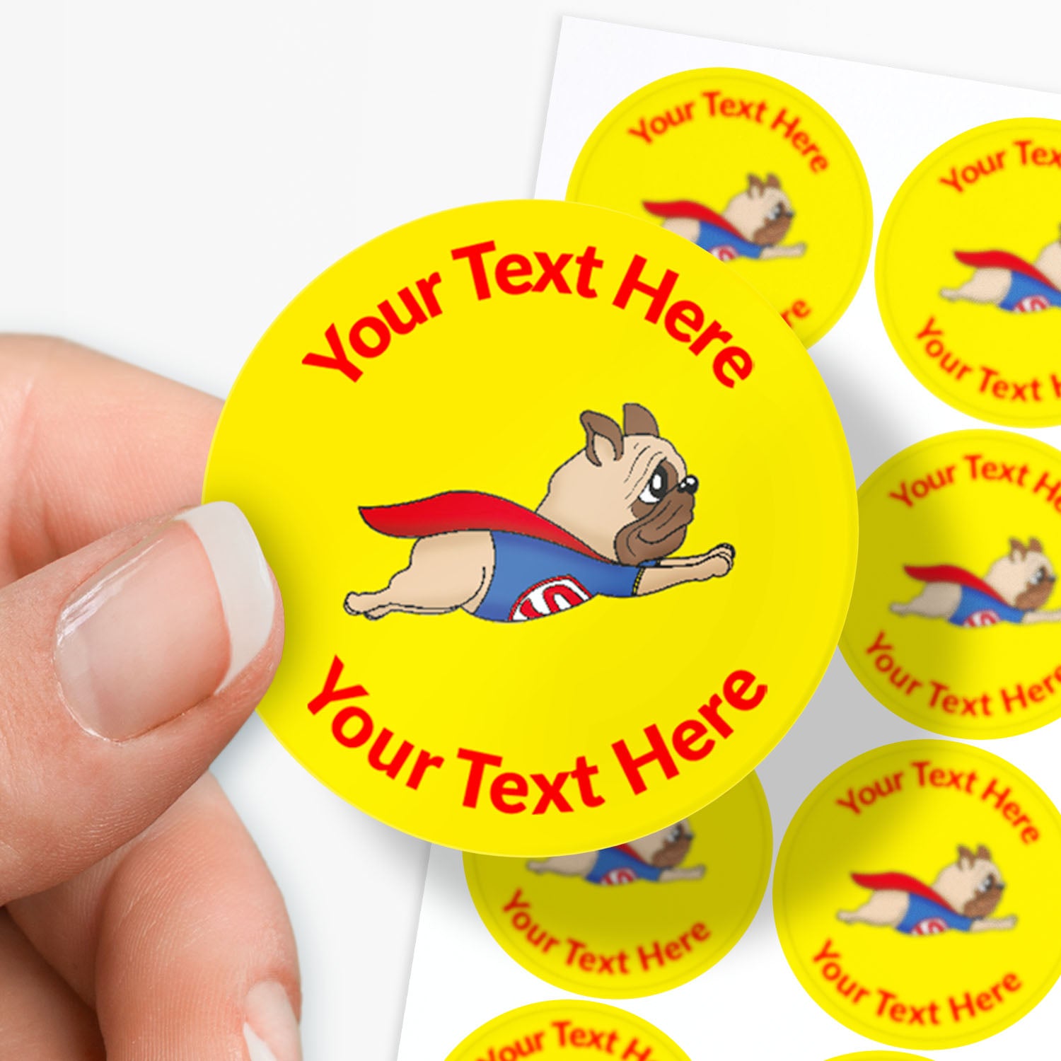 Circular stickers with a superhero dog design and customizable text, held by a hand.