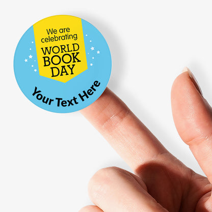 Round sticker with 'We are celebrating World Book Day' text held by a finger on a white background