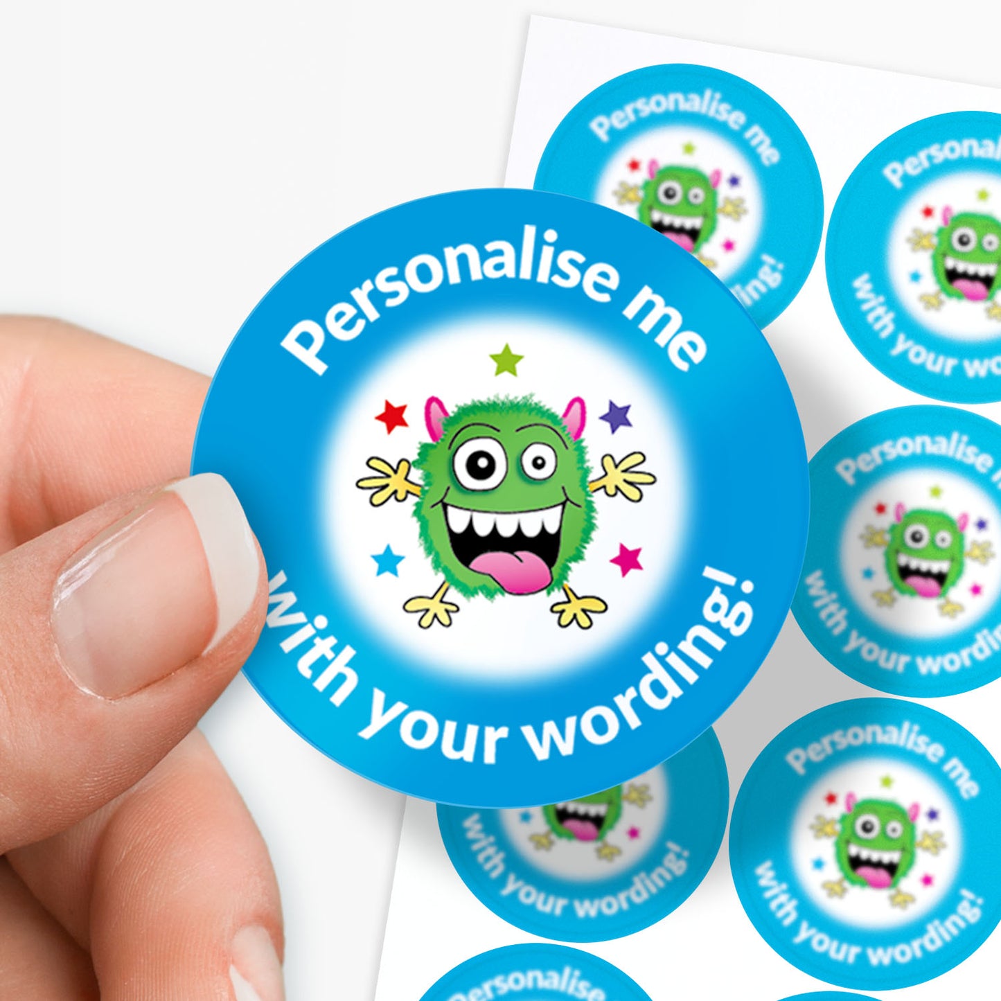 Circular stickers with a green monster design and text 'Personalise me with your wording!' held by a hand.