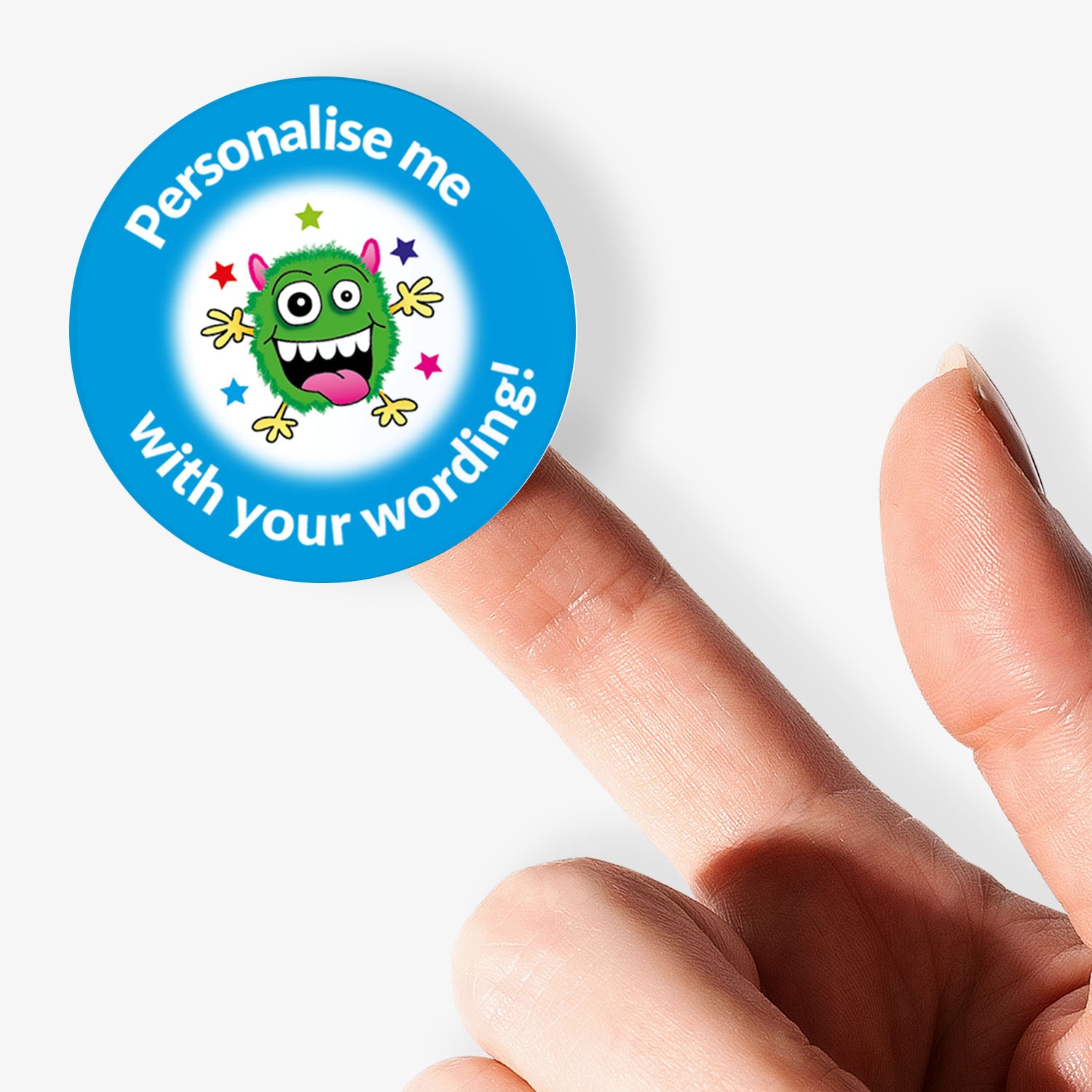 Circular sticker with a monster graphic and text 'Personalise me with your wording!' held between fingers.