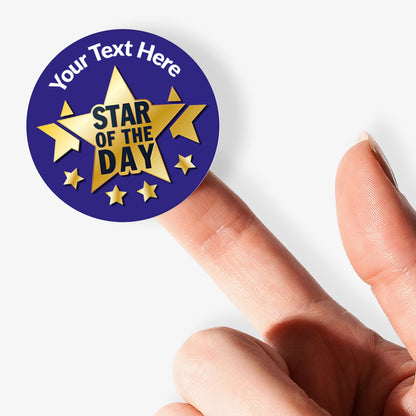 Personalisable 'Star of the Day' sticker held on a finger on a white background