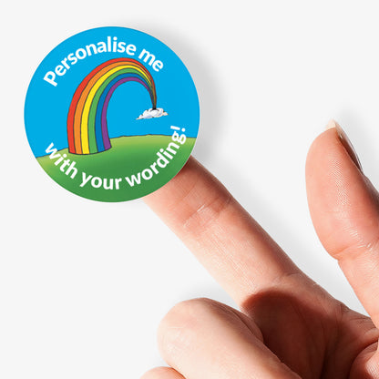 Turquoise sticker, on a finger, with a rainbow as the central image.  Space for personalisation above and below the image.