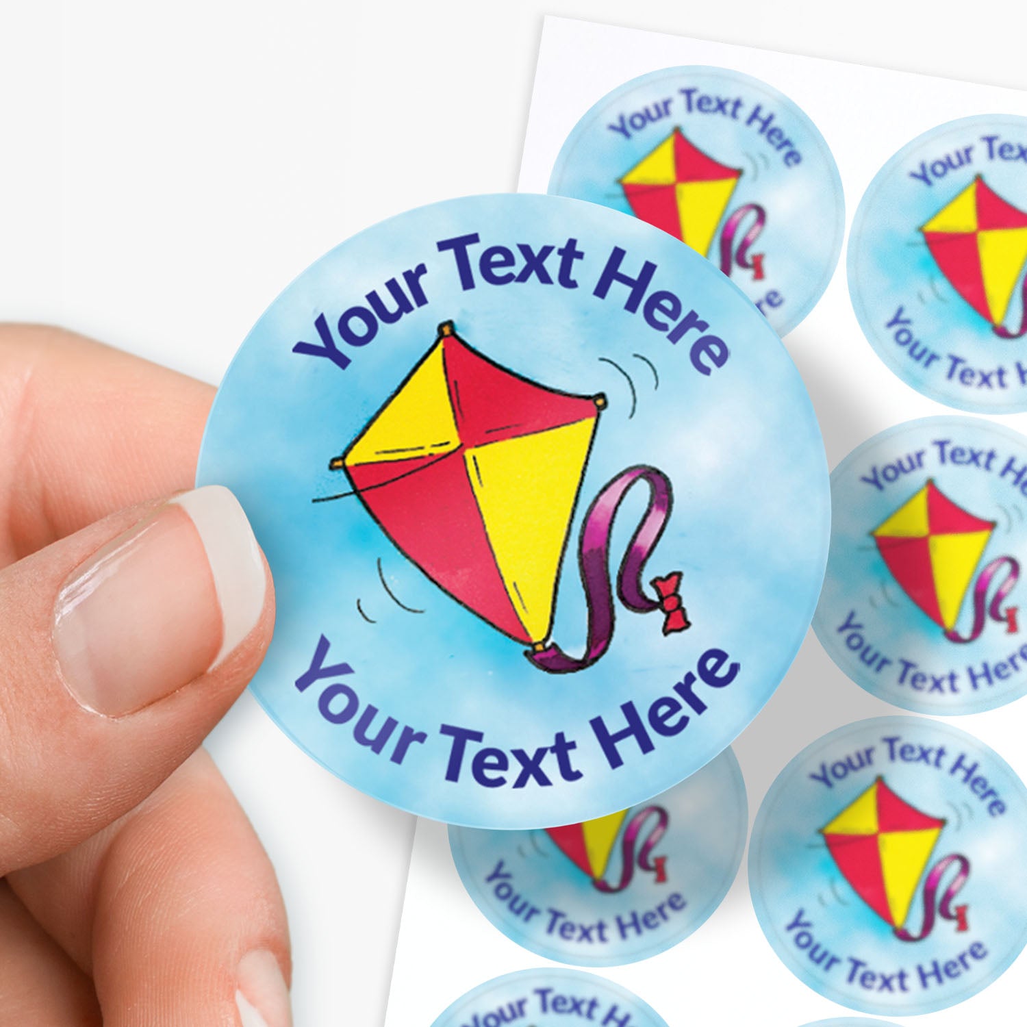 Personalizable stickers with a kite design and 'Your Text Here' text, held by a hand.