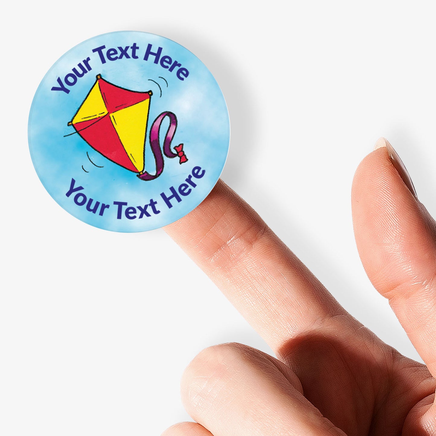 Personalizable sticker with kite design held by a finger on a white background