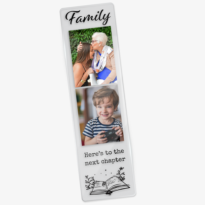 Clear acrylic bookmark featuring the phrase 'family' at the top, two family themed images, and the words 'here's to the next chapter' above an illustrated open book with magical elements.
