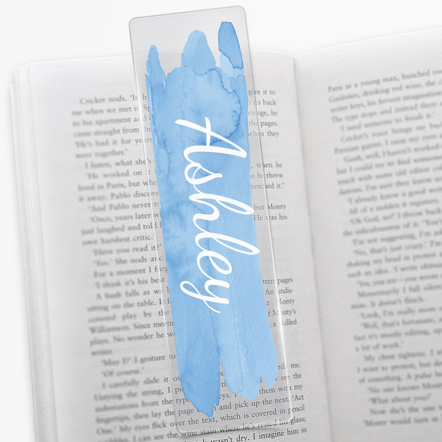 Acrylic bookmark with a pale blue watercolour brush stroke vertically down the middle with white script font 'Ashley'.