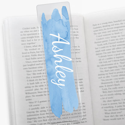 Acrylic bookmark with a pale blue watercolour brush stroke vertically down the middle with white script font 'Ashley'.