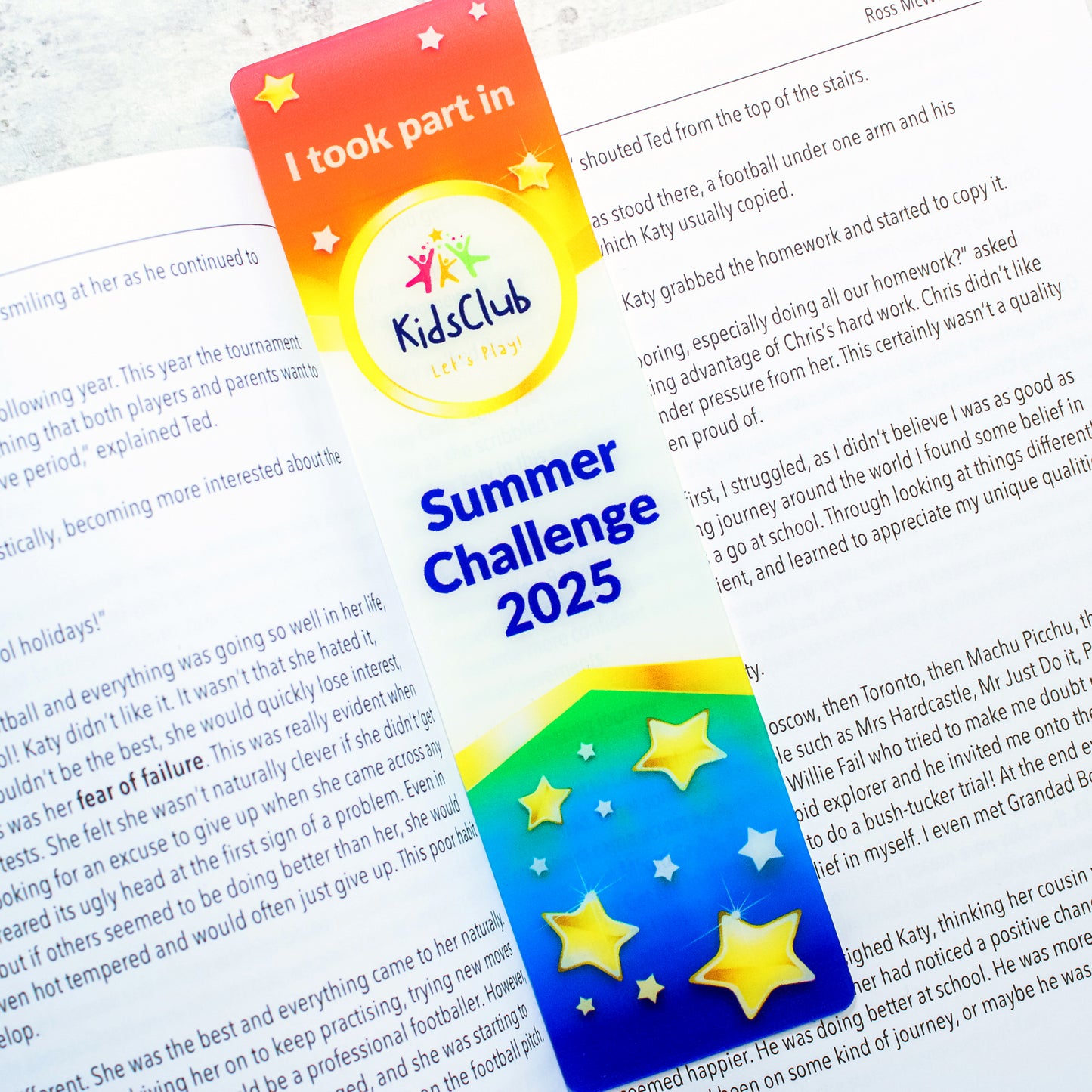 Acrylic Bookmark ontop of book rainbow coloured design with kids club and summer challenge wording 
