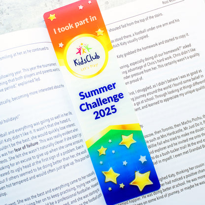 Acrylic Bookmark ontop of book rainbow coloured design with kids club and summer challenge wording 