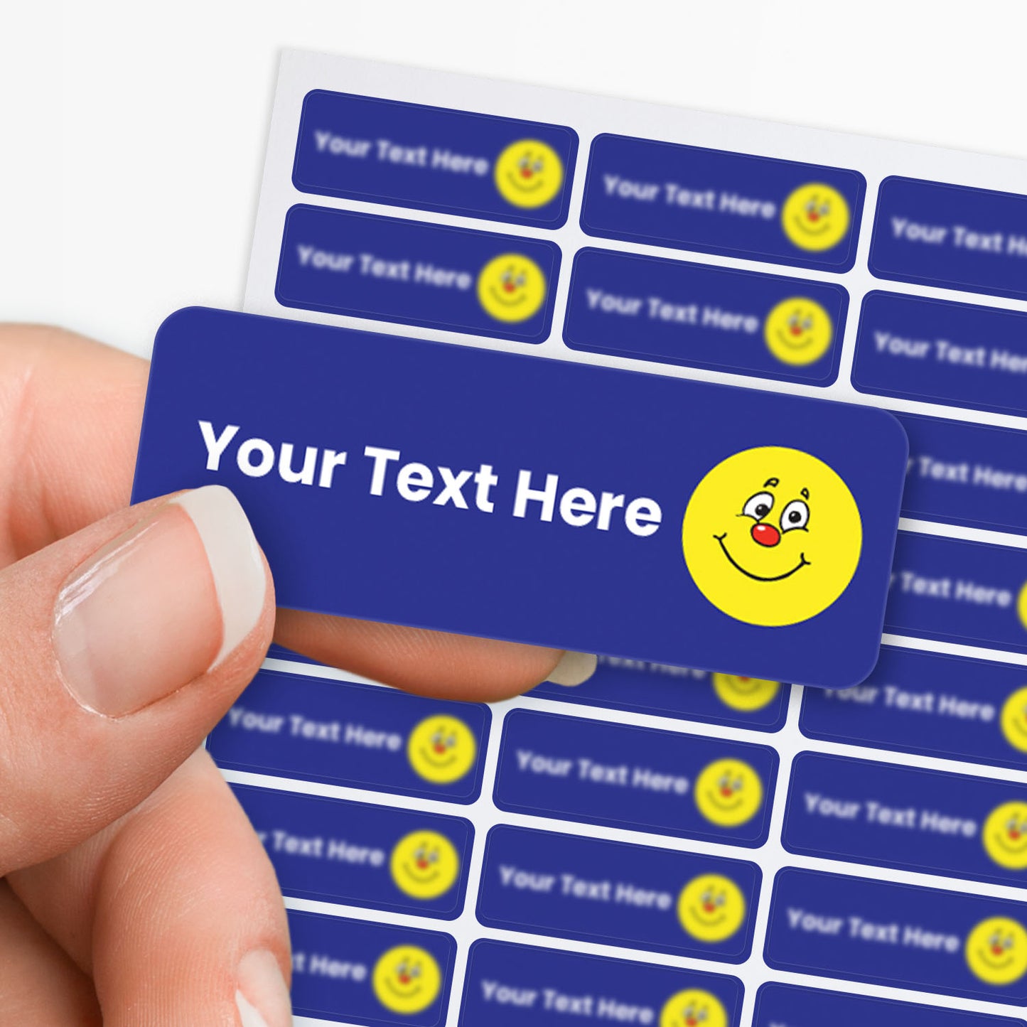Blue stickers with white text and a yellow smiley icon held by a hand with a sheet in the background