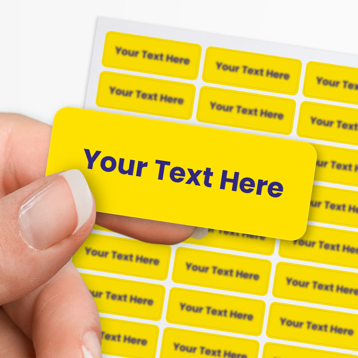 Yellow stickers with blue text held by a hand with sheet of stickers in the background