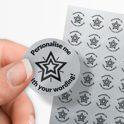 Circular sticker with star design and text 'Personalise me with your wording!' held by a hand, with a sheet of similar stickers in the background.
