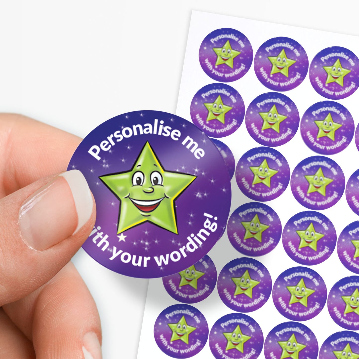 Sheet of circular stickers with a cartoon star and text on a white background. Single sticker held between finger and thumb
