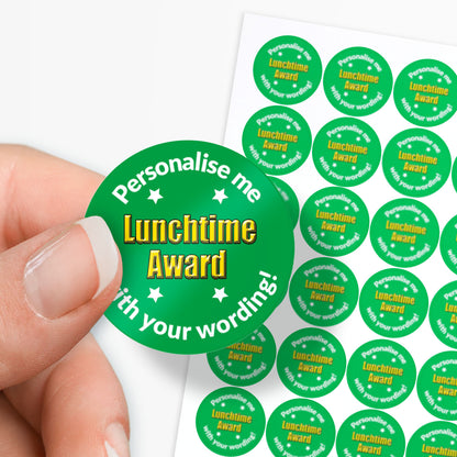 Sheet of circular stickers with a Lunchtime Award and text on a white background. Single sticker held by finger and thumb