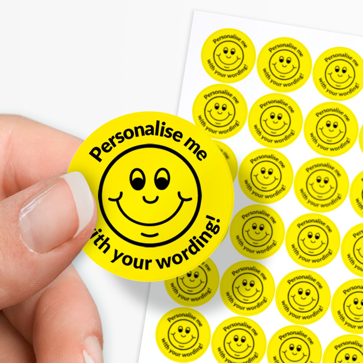 Circular stickers with a smiley face and text on a white background held 
by finger and thumb