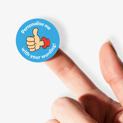 Blue sticker on a finger with a thumbs up as a central image.  'Personalise me with your wording!' surrounds the image.