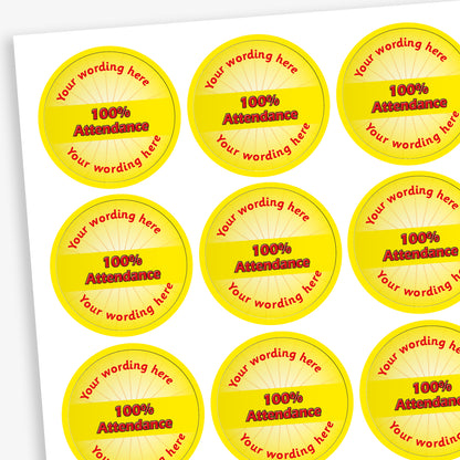 Sheet of 70 round, yellow stickers, each 25mm in diameter, featuring bold yellow text reading '100% Attendance' at the centre. Surrounding the central text is placeholder wording 'Your wording here' above and below, indicating customisable areas for personalised messages.
