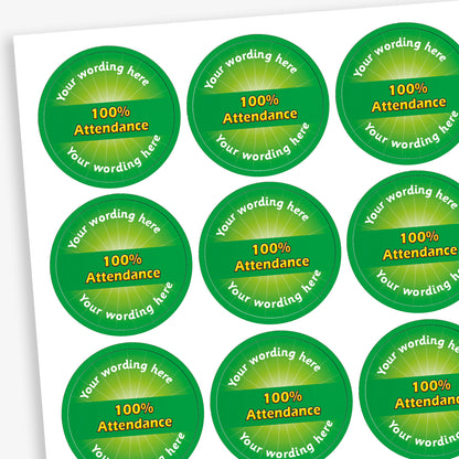 Sheet of 70 round, green stickers, each 25mm in diameter, featuring bold yellow text reading '100% Attendance' at the centre. Surrounding the central text is placeholder wording 'Your wording here' above and below, indicating customisable areas for personalised messages.