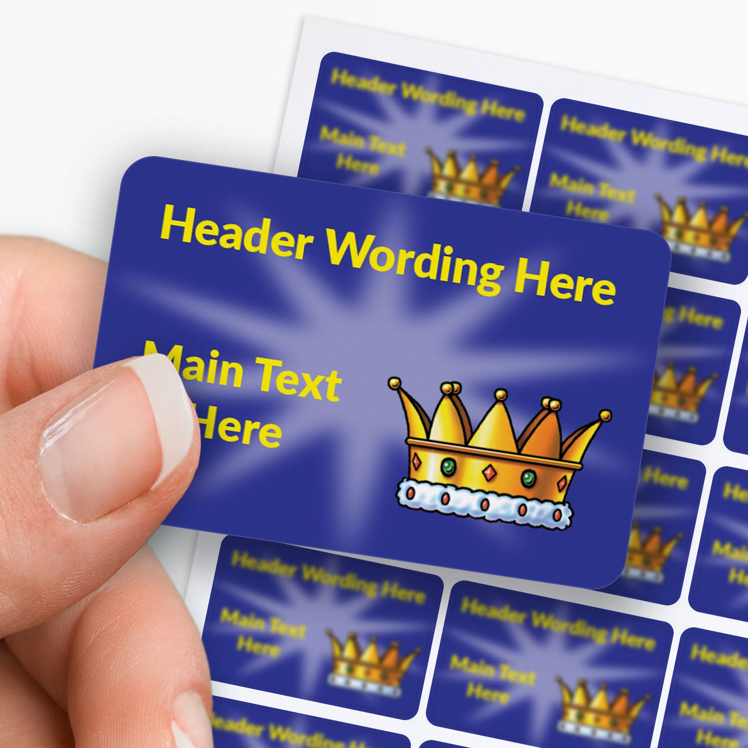Blue stickers with yellow text and a crown icon held by a hand with sheet in the background